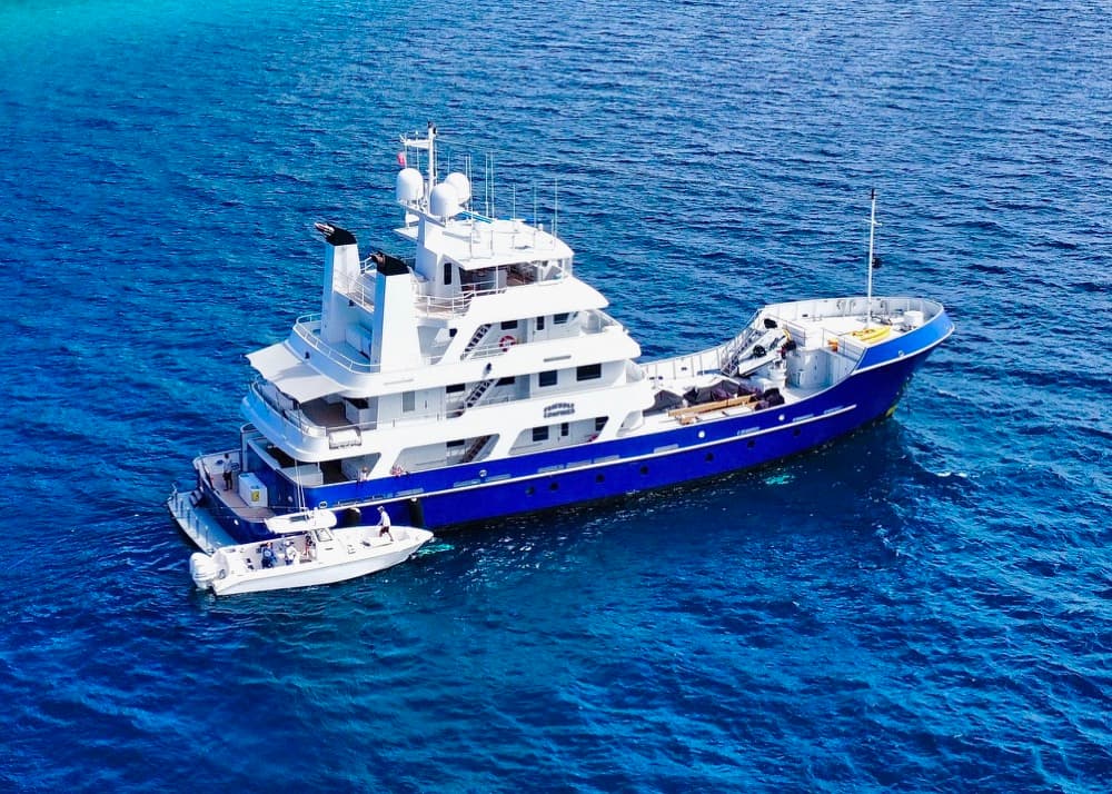 An explorer yacht at anchor with tenders alongside